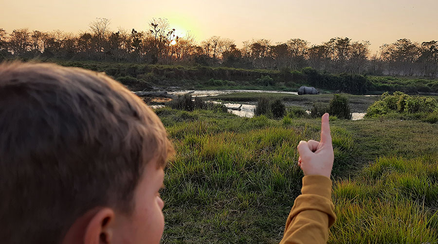 A junior traveler spotting One Horned Rhino during Chitwan Jungle Safari Tour